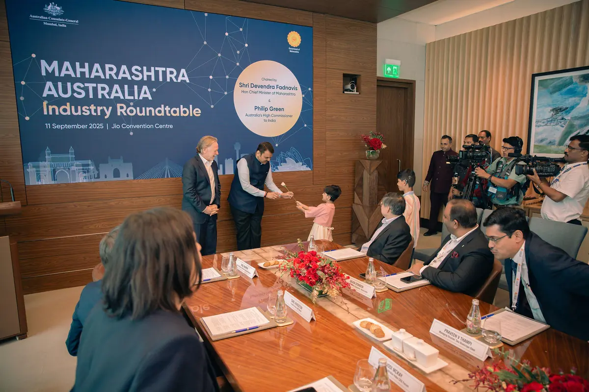 Child presents a rose to Devendra Fadnavis at the Maharashtra Australia Industry Roundtable